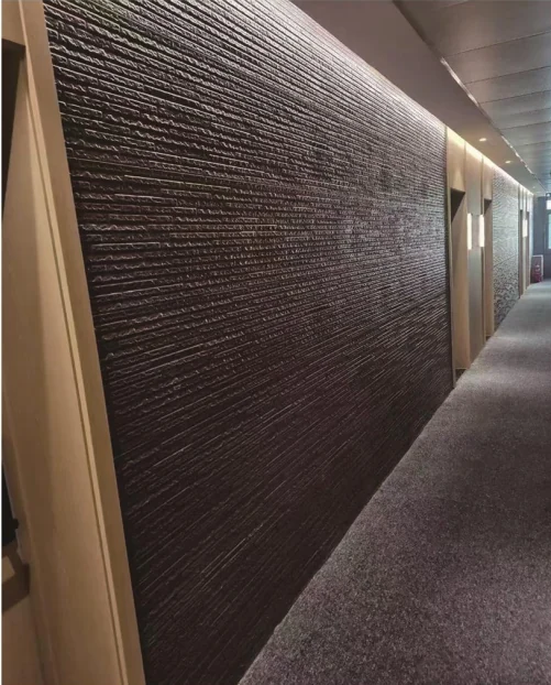 Textured dark wall panels along an interior corridor
